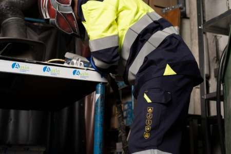 Trabajador usando ropa de protección ignífuga y antiestática: cazadora RIDE FRHV y pantalón STRIP FRHV, diseñadas para soldadura, combinando seguridad, comodidad y resistencia en entornos con riesgo de chispas y altas temperaturas.